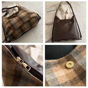 Close-up of brown plaid wool fabric, smooth leather straps and gold metal zipper details