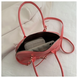 Detailed interior of the pink bowling bag showing spacious dark lining and daily items