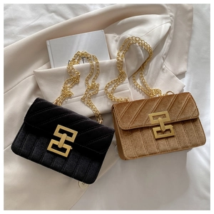 Detailed close-up of velvet crossbody bags with gold chain straps and geometric buckles