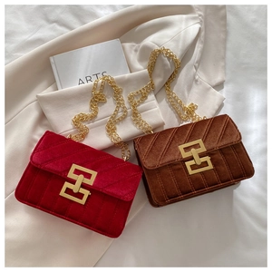 Detailed close-up of velvet crossbody bags with striped quilting and golden chain straps