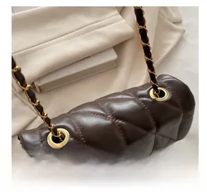 Detail of chocolate quilted leather handbag with gold chain strap and metal rings