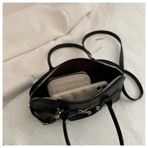 Top view of black leather bowling bag showing spacious interior with wallet and phone