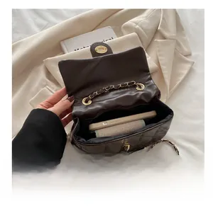 Top view detail of brown quilted chain bag showing interior capacity for a smartphone