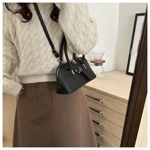 Detail einer Vintage Ledertasche in Schwarz mit Goldbeschlägen im Lifestyle-Ambiente