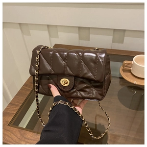 Détail du sac à bandoulière matelassé marron foncé avec fermoir doré rotatif