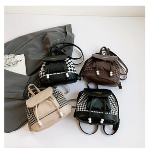 Detail showing four vintage houndstooth backpacks with leather flaps and drawstring closures