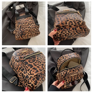 Detail view of leopard print backpack with gold zippers and internal storage compartments