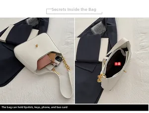 Detail of white leather shoulder bag showing spacious interior and golden chain strap