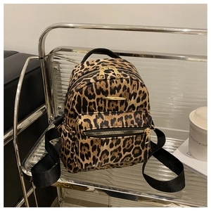 Close-up of mini leopard print backpack featuring gold-tone zippers and fuzzy texture