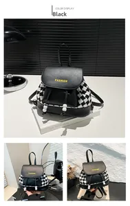Detail of black faux leather backpack with houndstooth stitching and yellow fashion text