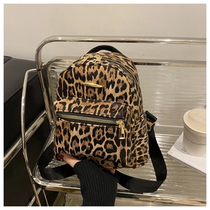 Detailed close-up of leopard print mini backpack featuring gold zippers and plush texture