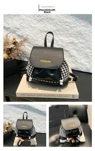 Detail of houndstooth plaid backpack with drawstring closure and fashion text branding