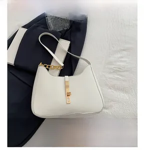 Detail view of crescent leather bag with gold chain strap and metallic buckle