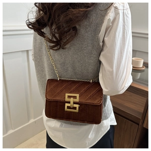 Detail of brown velvet crossbody bag with gold chain strap and quilted geometric texture