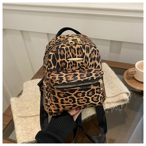 Detailed side view of mini leopard print backpack with gold zippers and black straps