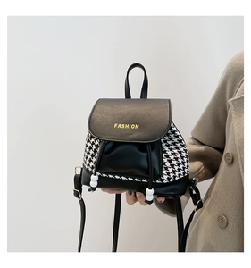Detail of vintage houndstooth backpack featuring gold lettering and bead drawstrings