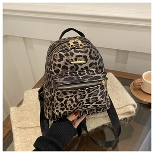 Detailed macro view of stylish leopard print backpack with gold metal zippers and texture