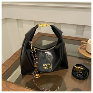 Detail of black glossy crescent hobo bag with gold hardware and COIH '2DN lettering
