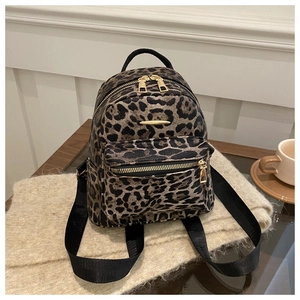 Close-up of leopard print backpack with gold-tone zipper and textured synthetic leather
