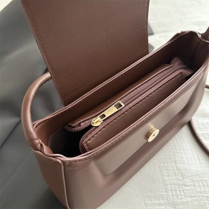 Chic brown leather baguette bag with gold hardware and spacious interior view