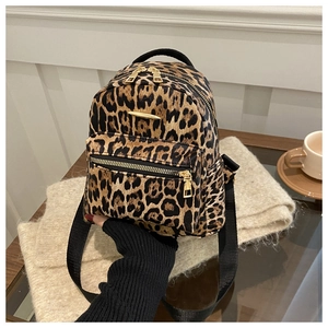 Detail of leopard print mini backpack with golden zippers and black nylon straps
