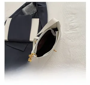 Internal view of the white leather shoulder bag showing the lining and zipper pocket