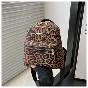 Detail of a leopard print mini backpack featuring golden metal zipper and fuzzy texture