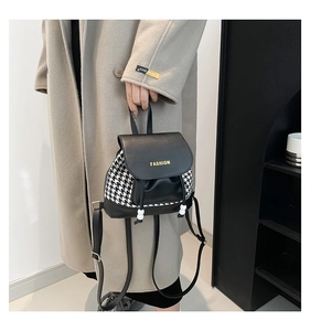 Detail of houndstooth mini backpack featuring leather trim and FASHION logo text