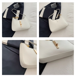 Detail view of white crescent hobo bag with gold piston clasp and chain strap accents