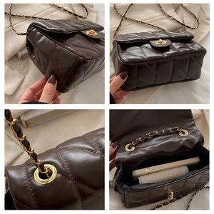 Detail view of brown quilted square bag featuring gold twist lock and chain strap