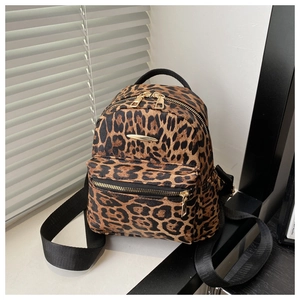 Close-up of mini leopard print backpack featuring triple zip pockets and gold hardware