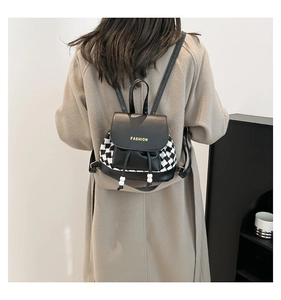 Rear view of a model wearing the houndstooth and black leather mini backpack