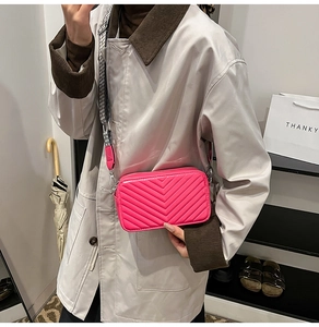 Sac bandoulière matelassé magenta avec sangle tissée géométrique sur un mannequin