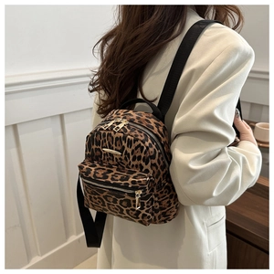 Detail of trendy leopard print mini backpack with golden metal zippers and black nylon straps
