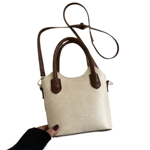 Retro cream and brown two-tone crossbody bucket bag with adjustable shoulder strap
