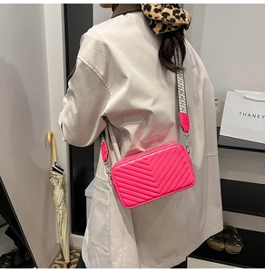 Dettaglio borsa a tracolla trapuntata magenta con ampia tracolla in tessuto geometrico