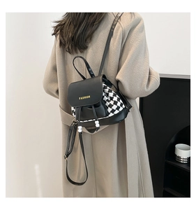 Detail of fashion houndstooth backpack with leather stitching and drawstrings on model