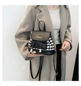 Detail of checkered fabric and black PU leather backpack with fashion logo and drawstrings