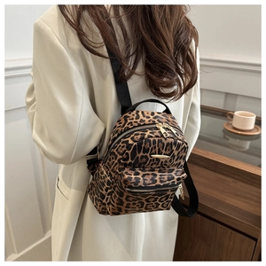 Rear view of a model wearing the mini leopard print backpack with a stylish beige blazer