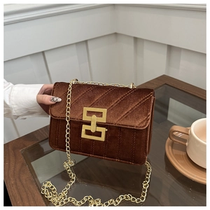 Detail of brown velvet crossbody bag with gold chain and H-shaped buckle closure