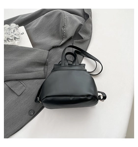 Detailed top view of a black matte leather mini backpack with gold hardware accents
