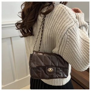 Détail du sac matelassé chocolat avec fermoir doré et bandoulière chaîne tressée