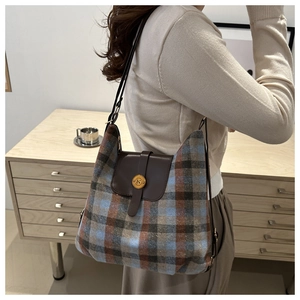 Detail of British style plaid shoulder bag with vintage gold buckle and leather strap