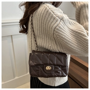 Détail du sac bandoulière matelassé marron foncé avec fermoir doré et chaîne sur mannequin