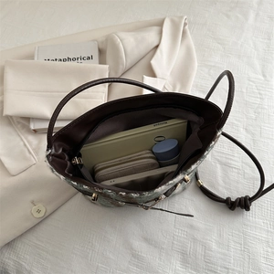 Chic tweed tote bag with spacious interior compartment showing daily essentials storage