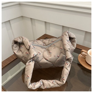 Detailed close-up of heart quilted nylon bag with floral print and knotted handle