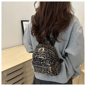 Detailed back view of a mini leopard print backpack worn with a casual gray hoodie