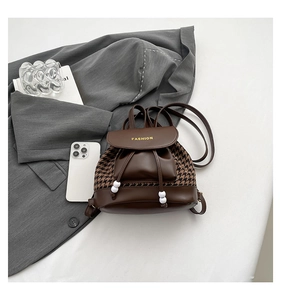Top view of a houndstooth mini backpack with drawstring and pearl bead detail