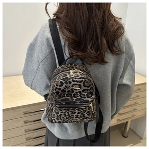 Detailed back view of a mini leopard print backpack with gold zipper and fabric straps