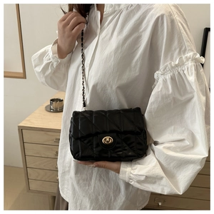 Détail du sac bandoulière matelassé noir avec fermoir doré et bandoulière chaîne
